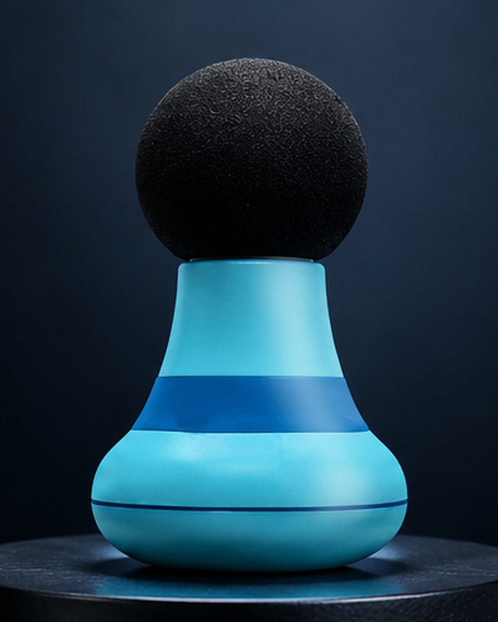 Mini masajeador muscular azul sobre fondo oscuro