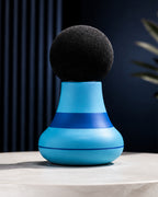 Mini masajeador azul con la bola de espuma, sobre pedestal