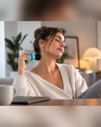 Mujer usando el mini masajeador en el cuello en el sofa