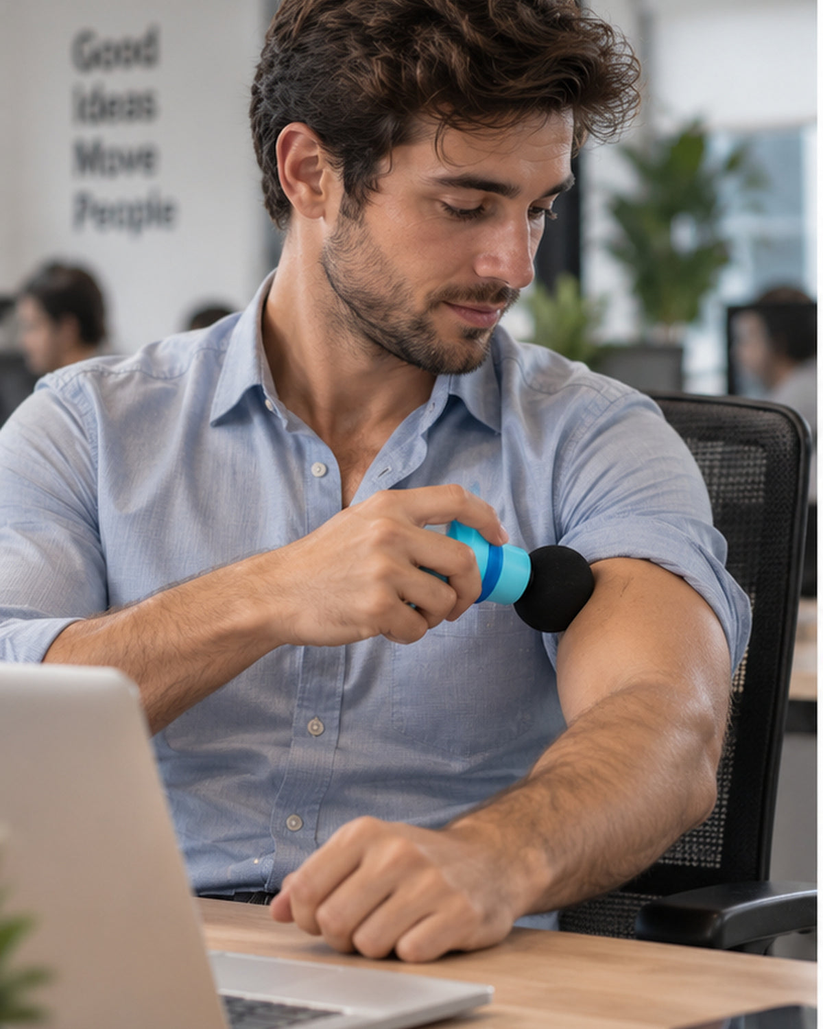 Hombre usando el mini masajeador en el brazo en la oficina